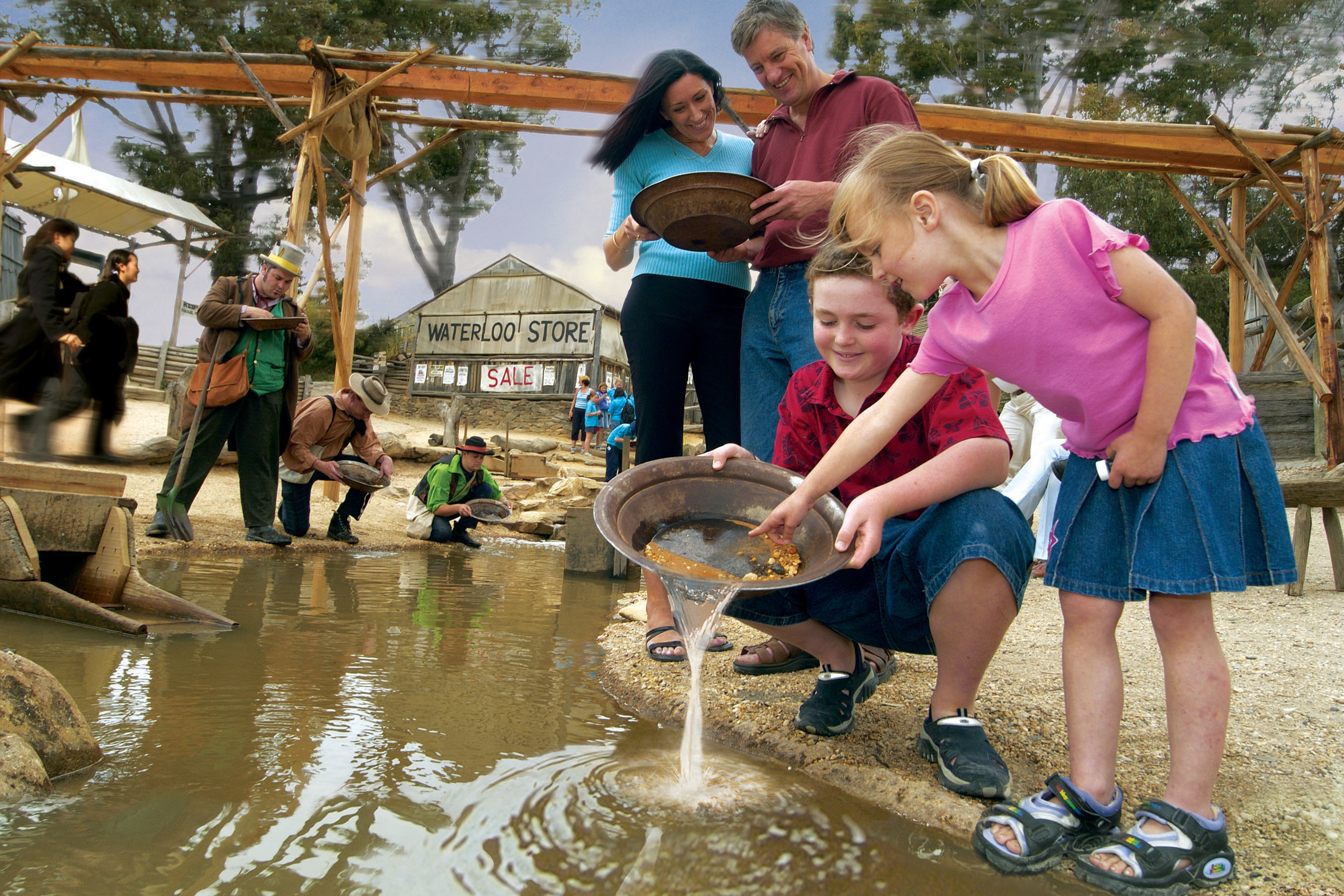 Family learning to pan for gold on shore excursion in Alaska.